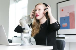 Woman in front of microphone, removing her headphones