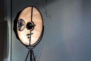 A single professional lighting mount, shines a light toward something off of the picture.