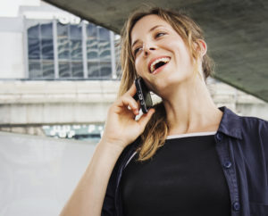 Smiling woman on her cell phone, having a delightful conversation