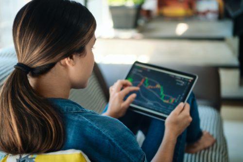 Woman Trading Online With Tablet On Sofa